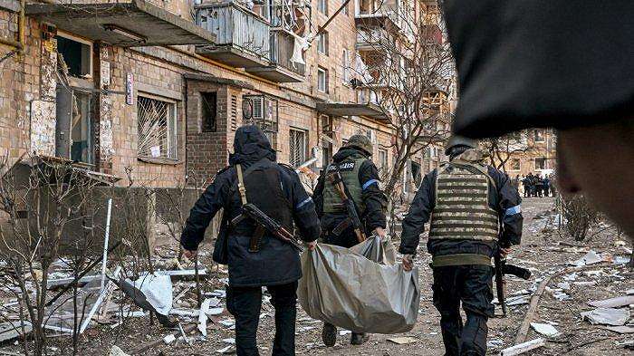 Polisi Ukraina membawa mayat dari sebuah bangunan perumahan lima lantai yang sebagian runtuh setelah penembakan di Kyiv pada 18 Maret 2022, ketika tentara Rusia mencoba mengepung ibukota Ukraina.